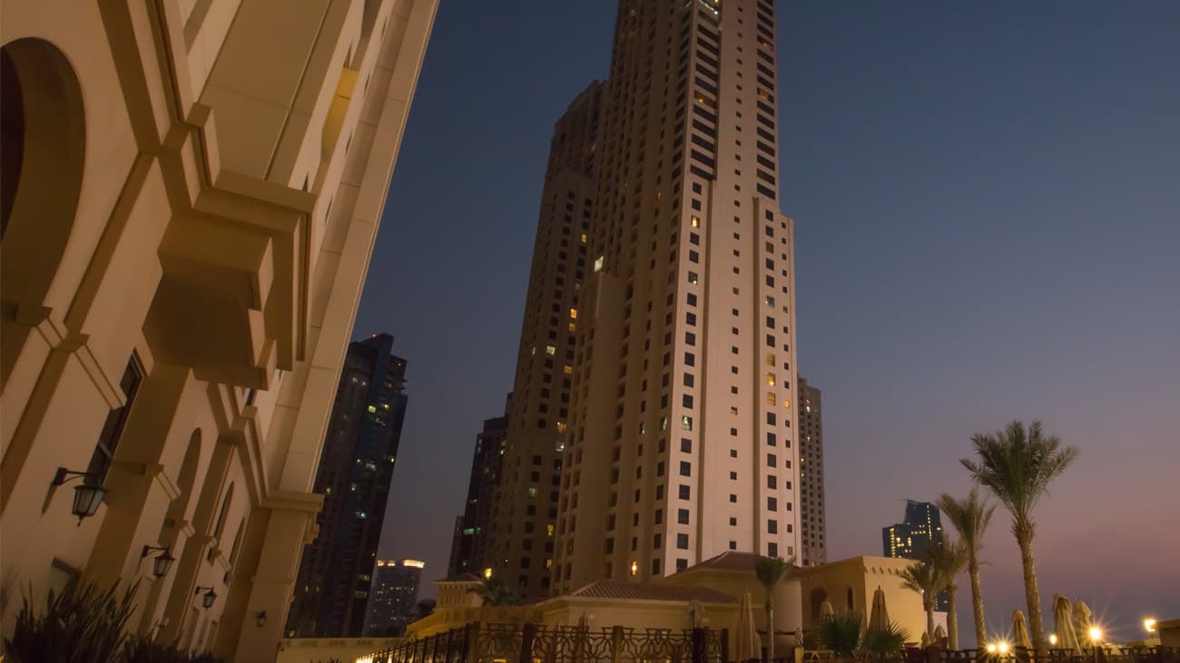 Jumeirah Beach Residence towers and the arches along The Walk at dusk