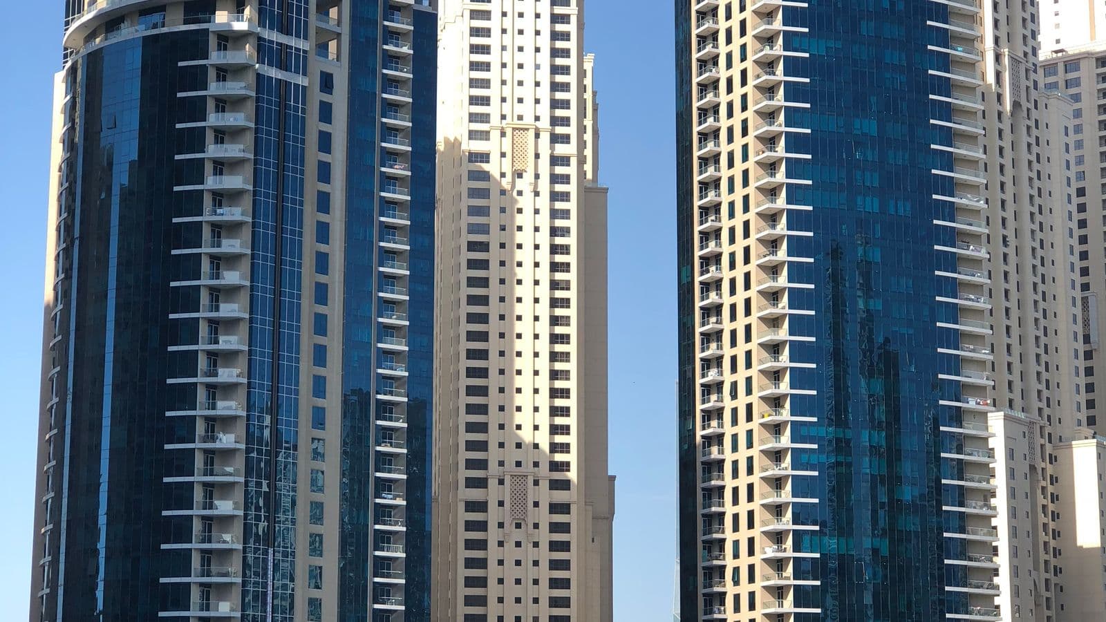 Waterfront high-rise residential towers under a clear sky