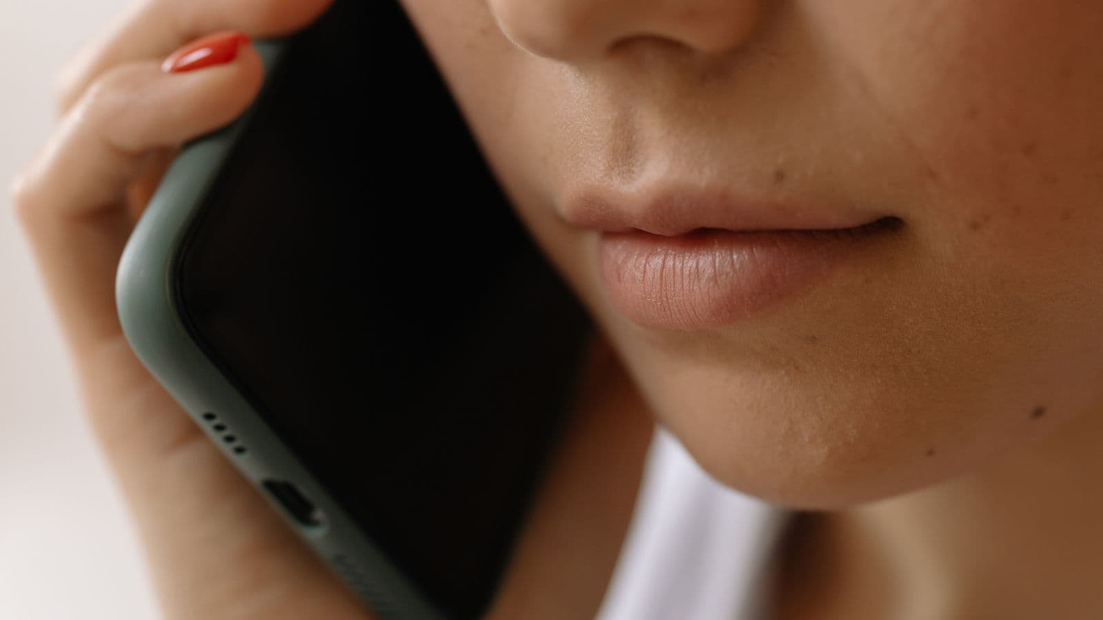 Close-up of a woman holding a smartphone to her ear during a phone conversation